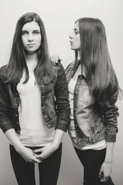 两个时尚的年轻女性在画室里摆姿势 牛仔裤夹克黑白图像 — 图库照片
