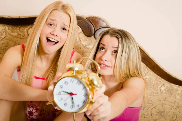 Två lekfulla glada sexiga blonda tjejer i rosa pyjamas som har roligt i sovrummet — Stockfoto
