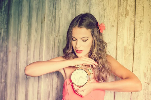 木製コピー スペース背景に目覚まし時計を持って楽しんで魅力的な若い女性の肖像画 — ストック写真