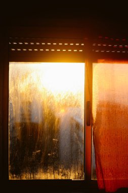 Bulanık, yoğunlaştırılmış yağmur damlalarına, parlayan gökyüzüne ve pencereli binalara yakın çekim