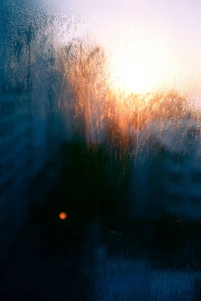 遮遮掩掩的冷凝水滴落在阳光灿烂的天空和结构良好的窗户背景下 — 图库照片