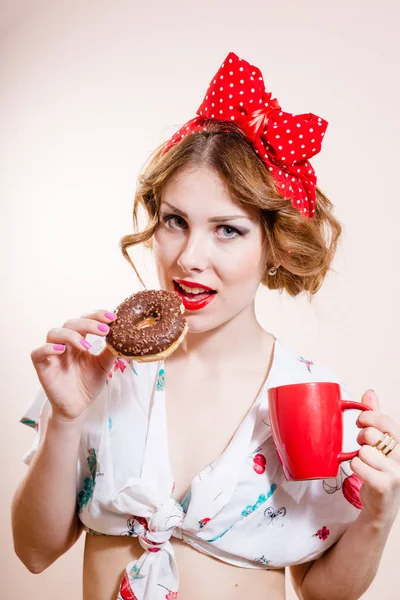 Close-up retrato de pinup menina bela loira jovem com excelentes dentes de cuidados dentários se divertindo comer donut e beber café olhando para a câmera no fundo branco — Fotografia de Stock