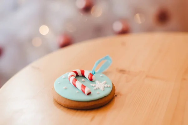 Biscuit au gingembre sur la table, près de l'arbre de Noël blanc, avec lumières bokeh dorées — Photo