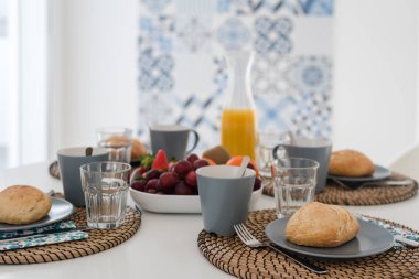 Taze kabuklu ekmek ve gri tabakta bir bardak meyve suyu ile tabak