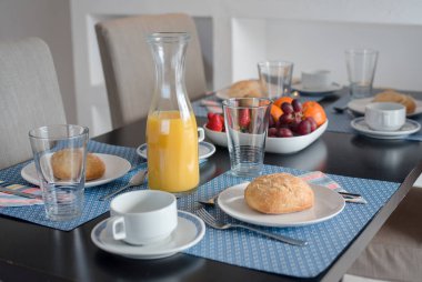 Beyaz tabakta taze kabuklu ekmek ve bir bardak meyve suyu ile tabak