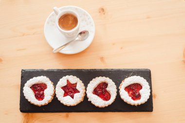 İtalyan kahve fincanı ve kurabiyesi beyaz Noel ağacının yanındaki masanın üzerinde.