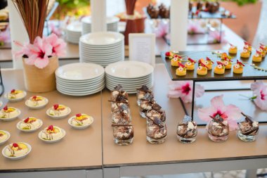 Etkinlikler için yemek büfesi. Düğün resepsiyonu tatlı masası. Lezzetli beyaz kapkekler ve böğürtlenli yakın plan..