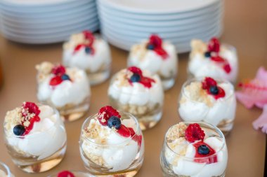 Etkinlikler için yemek büfesi. Düğün resepsiyonu tatlı masası. Lezzetli beyaz kapkekler ve böğürtlenli yakın plan..