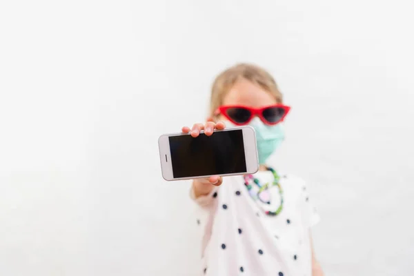 Little Blond Girl Wearing Disposable Mask Sunglasses Holding Mobile Phone — Stock Photo, Image