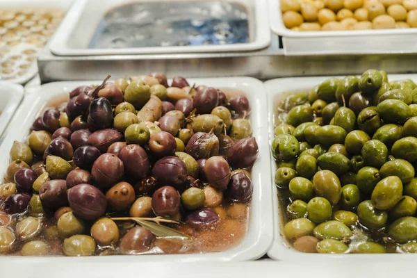 Assortment of olives, pickles and salads on market stand — Stock Photo, Image