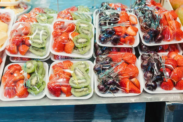 Фруктовый салат организован в пластиковые чашки на рынке киоск с небольшой вилкой внутри, закуска — стоковое фото