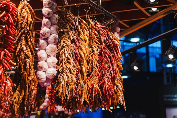 Red peppers, orange peppers, yellow peppers and garlic, hanged in the market — Stock Photo, Image