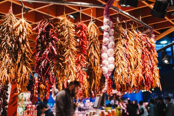 Red peppers, orange peppers, yellow peppers and garlic, hanged in the market — Stock Photo, Image