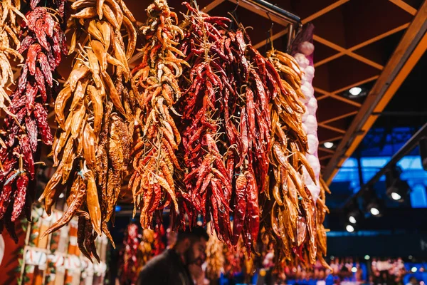 Red peppers, orange peppers, yellow peppers and garlic, hanged in the market — Stock Photo, Image