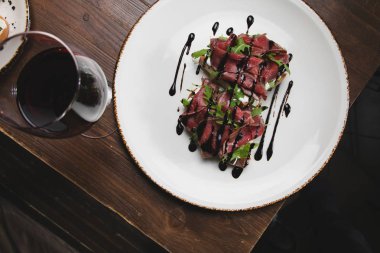 Füme etli bruschetta seti, kaba ahşap arka planda roka. Üst görünüm