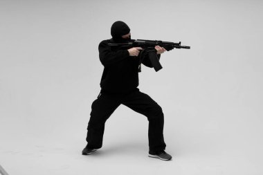 Beyaz arka planda silahlı maskeli bir adam.