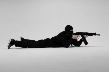 Beyaz arka planda silahlı maskeli bir adam.