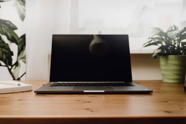 Eski ahşap bir masaya açık bir laptop..