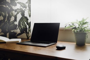 Eski ahşap bir masaya açık bir laptop..