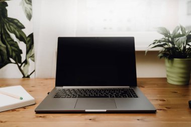Eski ahşap bir masaya açık bir laptop..