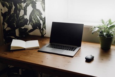 Eski ahşap bir masaya açık bir laptop..