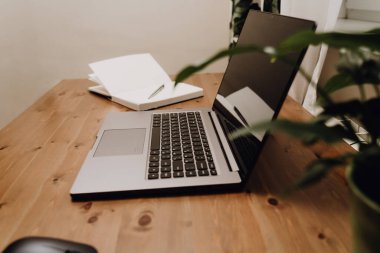 Eski ahşap bir masaya açık bir laptop..