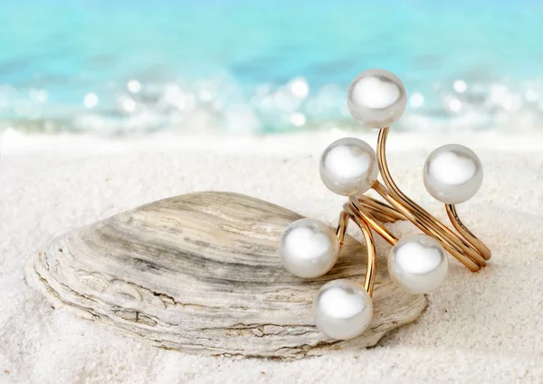 Zlatý prsten šperky s perlami na pískové pláži pozadí, měkké f — Stock fotografie
