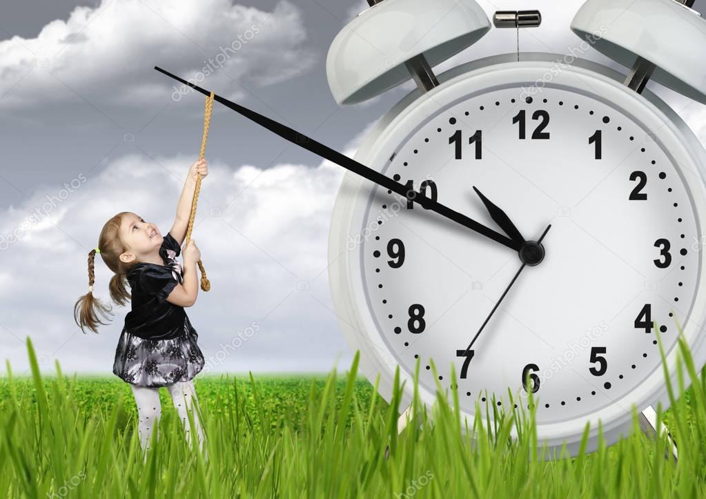 Little child pulling hand clock, time stop concept