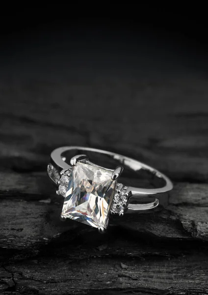 Schmuckring mit großem Diamanten auf dunklem Kohle-Hintergrund — Stockfoto