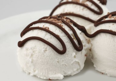 Beyaz çikolata soslu vanilyalı dondurma kaşık toz yakın çekim