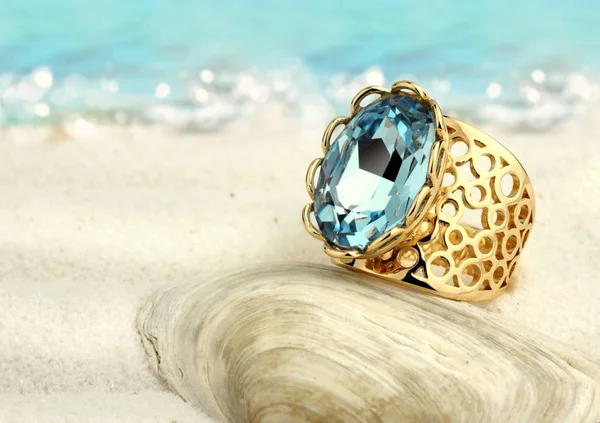 Smycken ring med aquamarine på sommaren sand beach — Stockfoto