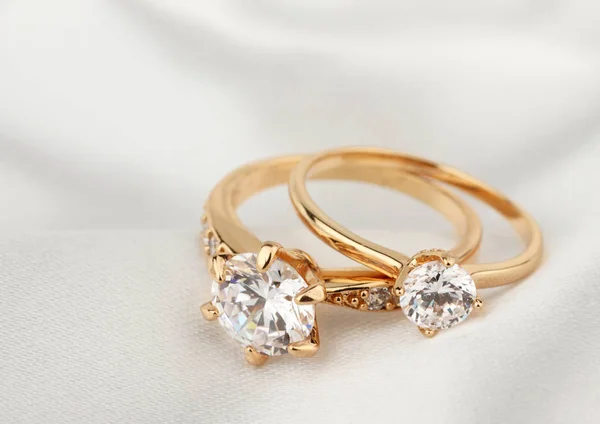 Anéis de jóias com diamante em pano branco, foco suave Fotos De Bancos De Imagens