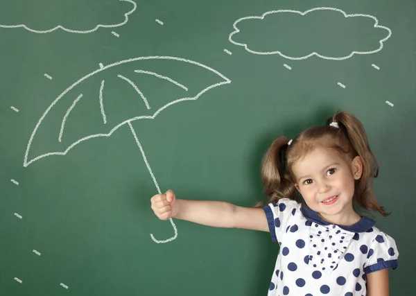 Criança menina guarda guarda-chuva perto da escola quadro negro, conceito de tempo — Fotografia de Stock