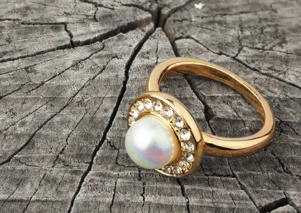 Pierścień biżuteria z perłami na tle drewna — Zdjęcie stockowe