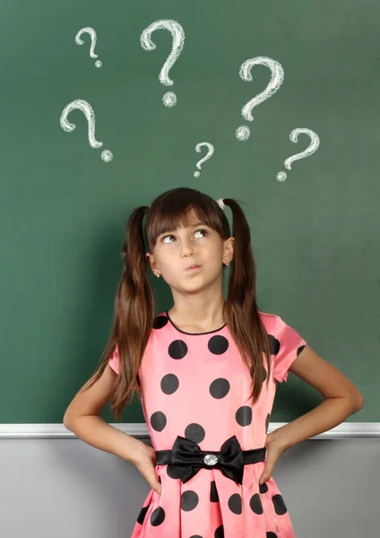 Menina com ponto de interrogação no quadro-negro da escola — Fotografia de Stock