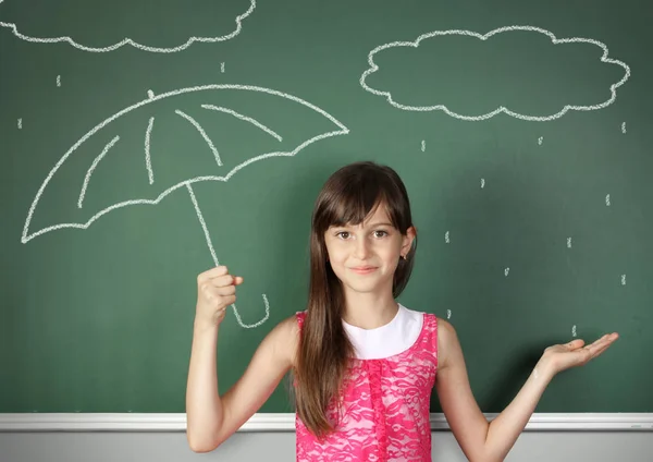 Bambino ragazza tenere ombrello vicino alla lavagna scuola, concetto meteo — Foto Stock