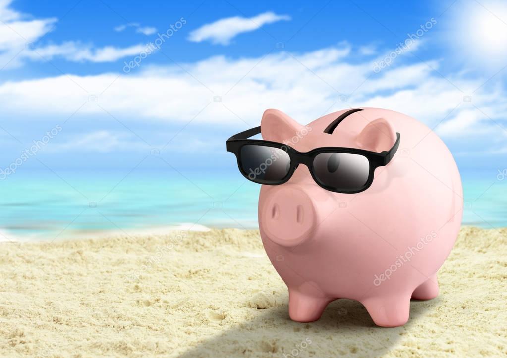 Piggy bank on the beach, money for travel concept