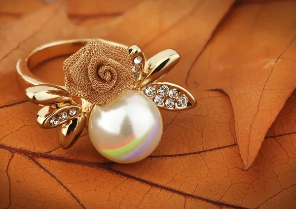 Smycken ring med pärla på Gula löv bakgrund — Stockfoto