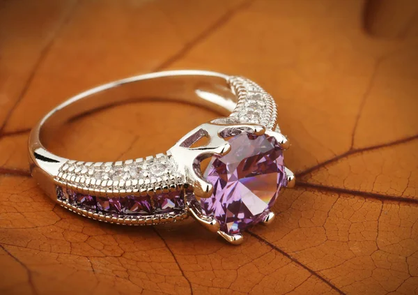 Smycken ring med ametist ädelsten på Gula löv bakgrund — Stockfoto