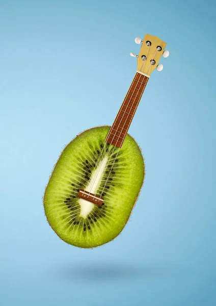 Creative cuisine concept, kiwi fruit as guitar on blue