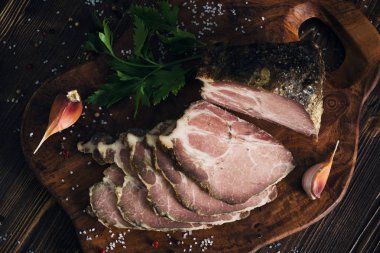 Domuz kayrak kesme tahtası üzerinde wo otlar ile pişmiş soğuk dilimlenmiş