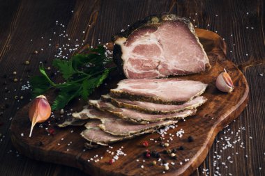 Domuz kayrak kesme tahtası üzerinde wo otlar ile pişmiş soğuk dilimlenmiş