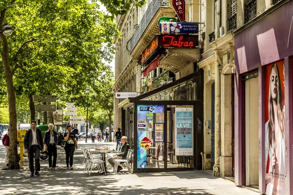 Hombre sentado en un bar típico con tabac shop y jardín de invierno —  Fotos de Stock