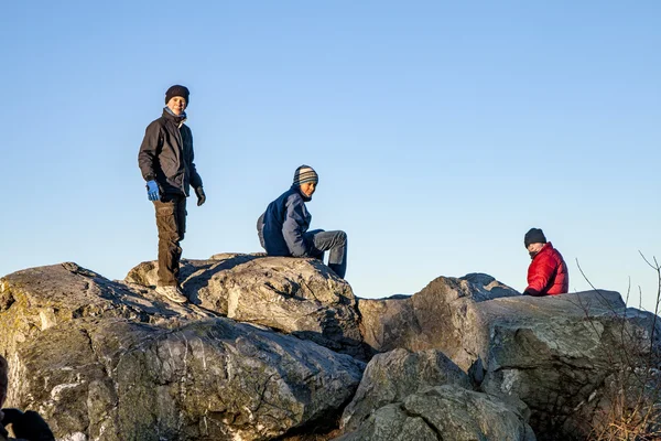 Trois amis s'amusent à grimper sur un rocher — Photo