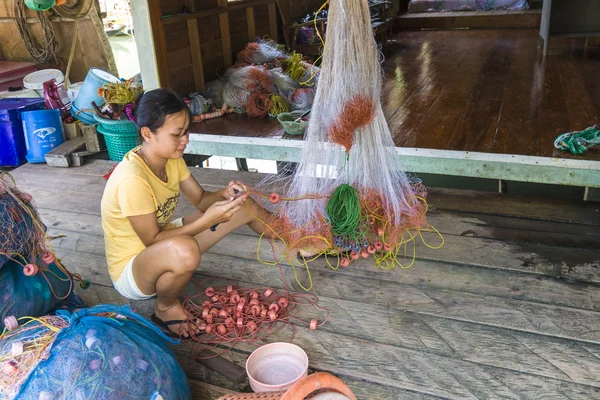 Local woman cleans the fishing net — Stockfoto