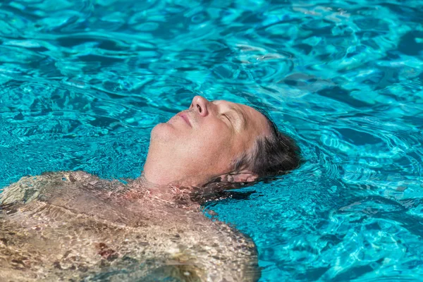 Hombre guapo disfruta nadar en la piscina — Foto de Stock