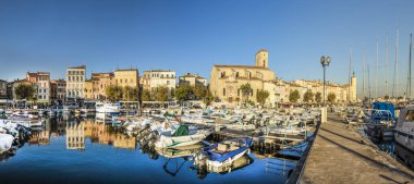 Mavi su içinde eski kasaba bağlantı noktası La Ciota yansıtan yatlar