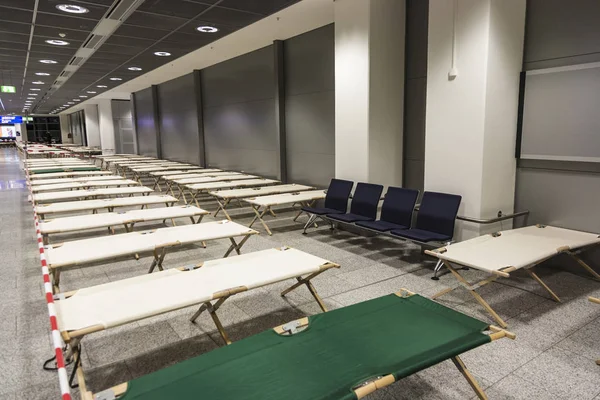 Camas de acampamento vazias estão em pé fileira por fileira no terminal do aeroporto — Fotografia de Stock