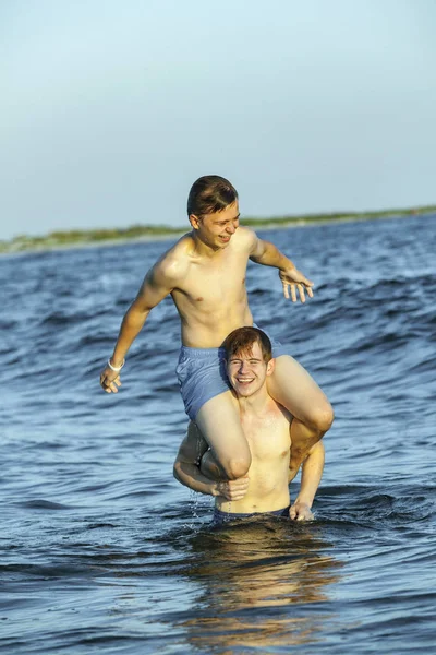 Мальчики наслаждаются прекрасным пляжем на островах Дофин — стоковое фото