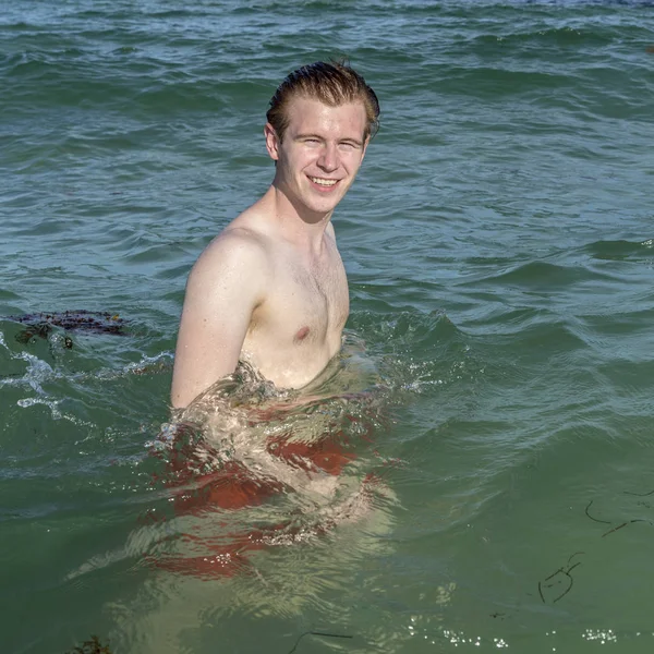 Adolescente ragazzo gode di nuotare nell'oceano — Foto Stock